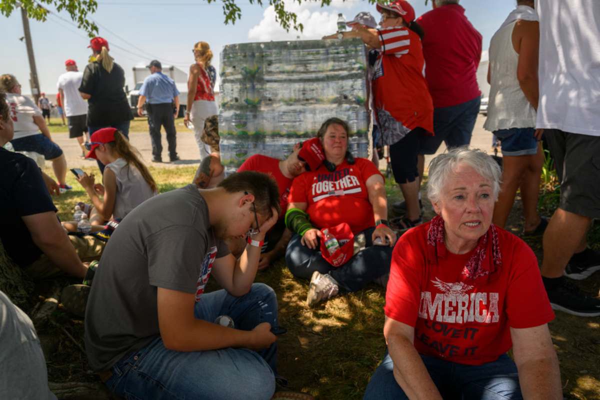 BUTLER, PENNSYLVANIA - JULY 13: Supporters seek shade while waiting in 92-degree weather for the start of a campaign rally for Republican presidential candidate, former U.S. President Donald Trump at Butler Farm Show Inc. on July 13, 2024 in Butler, Pennsylvania. Shortly after Trump began to speak, shots rang out and the former president slumped before being whisked away by Secret Service with injuries visible to the side of his head. Butler County district attorney Richard Goldinger said the shooter and one audience member are dead and another was injured. (Photo by Jeff Swensen/Getty Images)