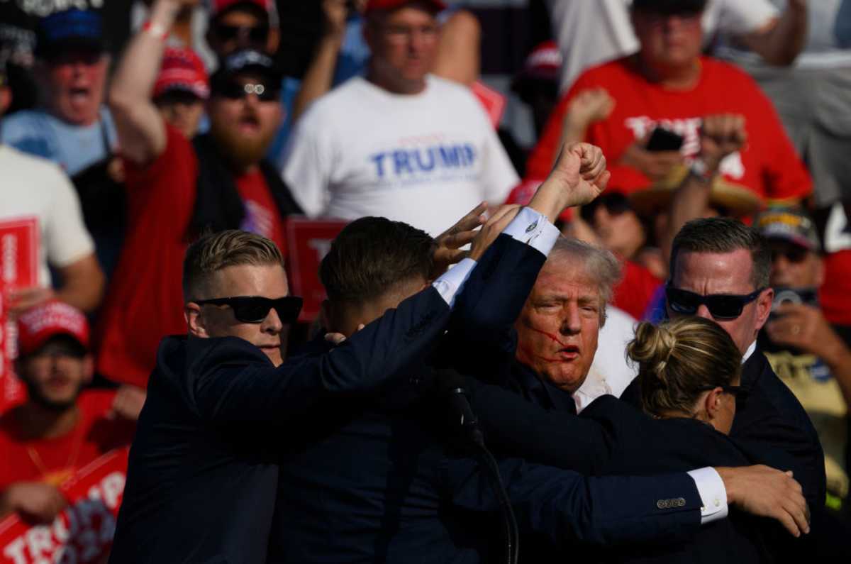 BUTLER, PENNSYLVANIA - JULY 13: Republican presidential candidate, former U.S. President Donald Trump is whisked away by Secret Service after shots rang out at a campaign rally at Butler Farm Show Inc. on July 13, 2024 in Butler, Pennsylvania. Trump slumped and injuries were visible to the side of his head. Butler County district attorney Richard Goldinger said the shooter and one audience member are dead and another was injured. (Photo by Jeff Swensen/Getty Images)