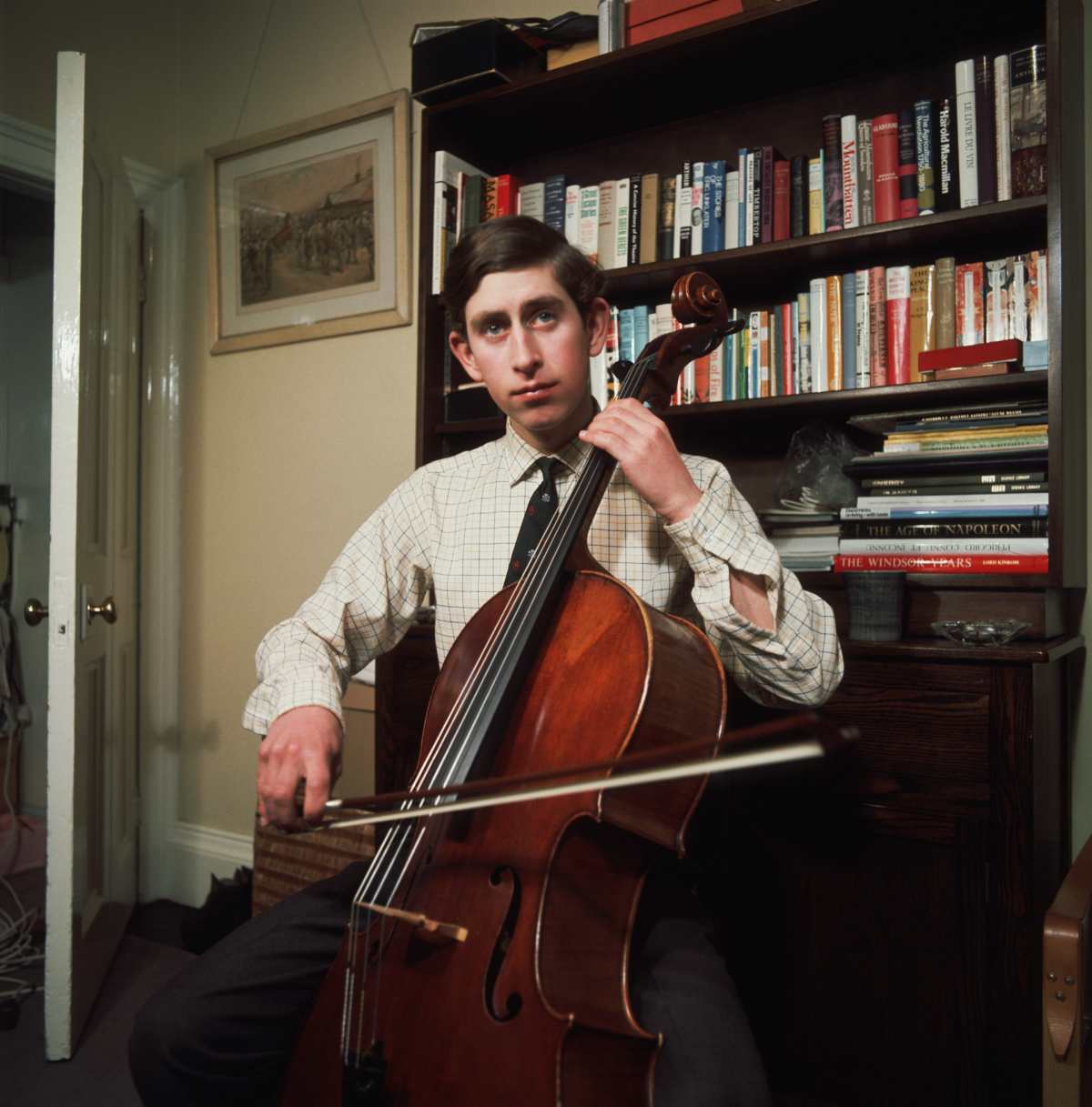 Prince Charles practices his cello playing in his rooms at Trinity College Cambridge, whilst an undergraduate there. (Image Source: Getty Images | Photo by © Hulton-Deutsch Collection)