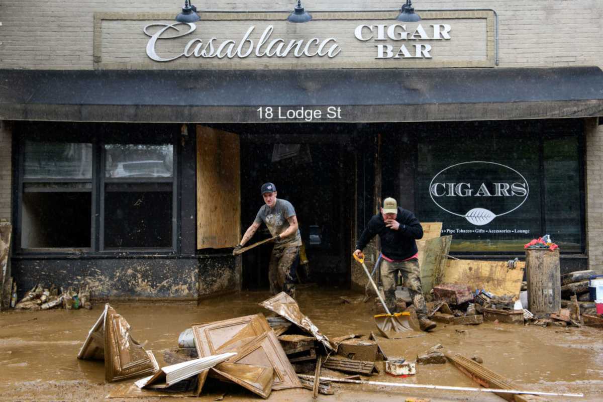 Lucas Ross, left, and Nathan Joudry clear mud and debris from Casablanca Cigar Bar in the aftermath of Hurricane Helene on October 1, 2024 in Asheville, North Carolina. (Image Source: Getty Images | Photo by  Melissa Sue Gerrits)