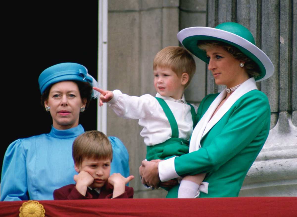 Diana, Princess Of Wales, Holding A Young Prince Harry In Her Arms As She Watches Trooping The Colour With Prince William And Princess Margaret From The Balcony Of Buckingham Palace. (Image Source: Getty Images / Photo by Tim Graham Photo Library)