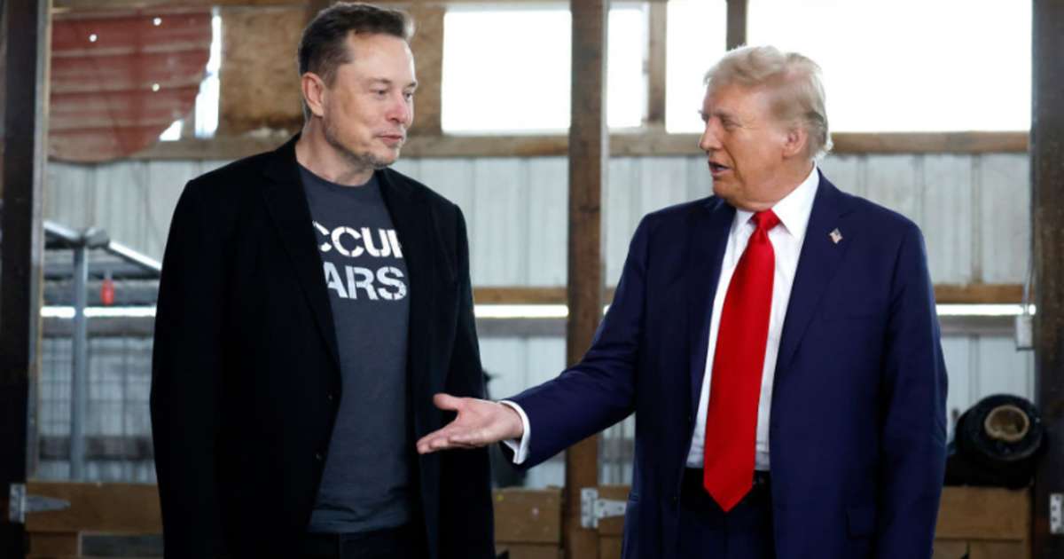 Donald Trump offers his hand to Elon Musk back stage during a campaign rally at the Butler Farm Show grounds on October 05, 2024 in Butler, Pennsylvania. (Image Source: Getty Images | Photo By Anna Moneymaker)