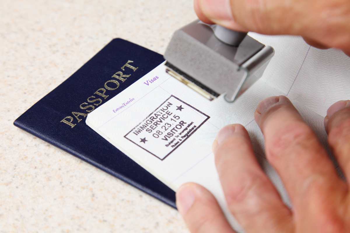 Stamping Passports - stock photo. (Image Source: Photo by gchutka / Getty Images)