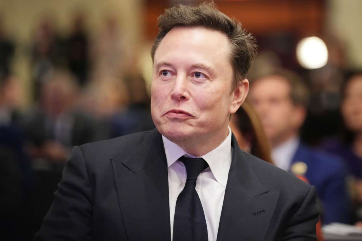 Elon Musk listens as U.S. President-elect Donald Trump addresses a House Republicans Conference meeting at the Hyatt Regency on Capitol Hill on November 13, 2024 in Washington, DC.(Image Source: Photo by Andrew Harnik/Getty Images)