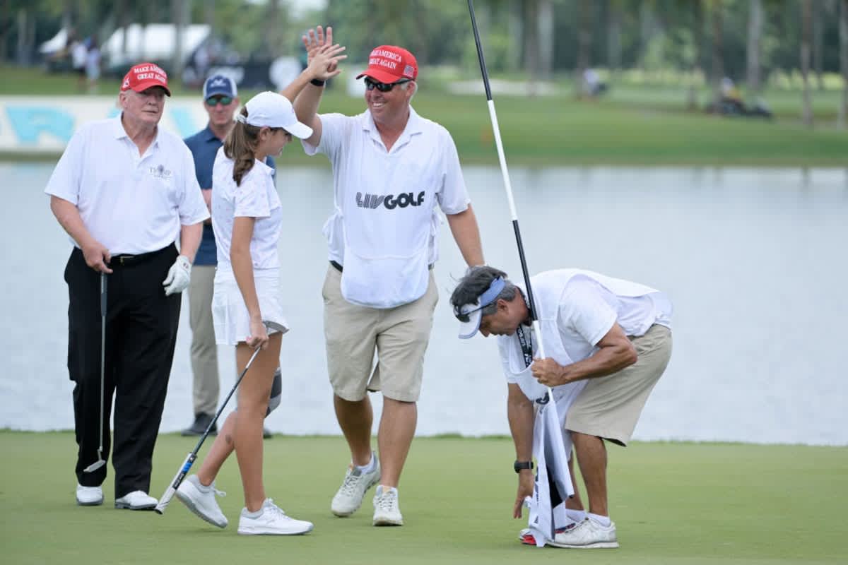 Kai Trump, granddaughter to former U.S. President Donald Trump (L), reacts on the 18th green during a pro-am prior to the LIV Golf Invitational - Miami at Trump National Doral Miami on October 27, 2022 in Doral, Florida. (Image Source: Photo by Charles Laberge/LIV Golf via Getty Images)