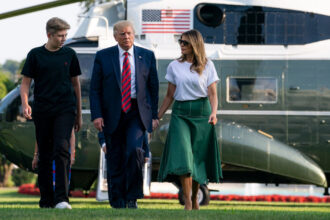 Donald J. Trump, Melania Trump, and their son, Barron, walk across the South Lawn of the White House